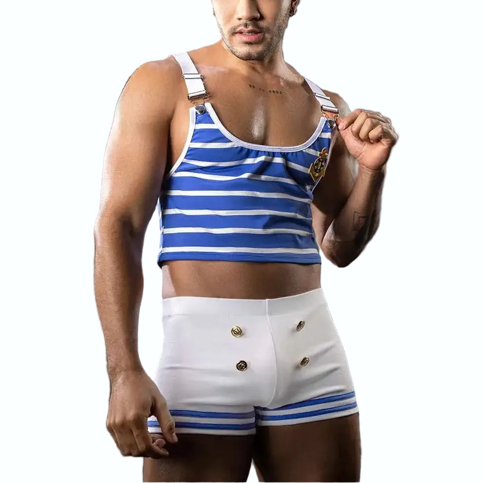 Man wearing a blue and white striped tank top and shorts with a captain's hat on a dark background