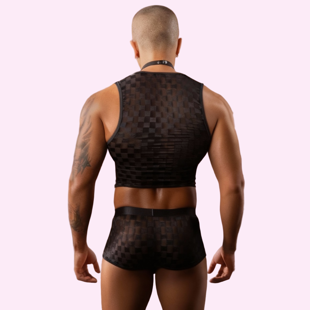 Person wearing black mesh lingerie in a pink bedroom