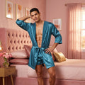 Man in a blue satin robe standing in a bedroom with pink walls and furniture.