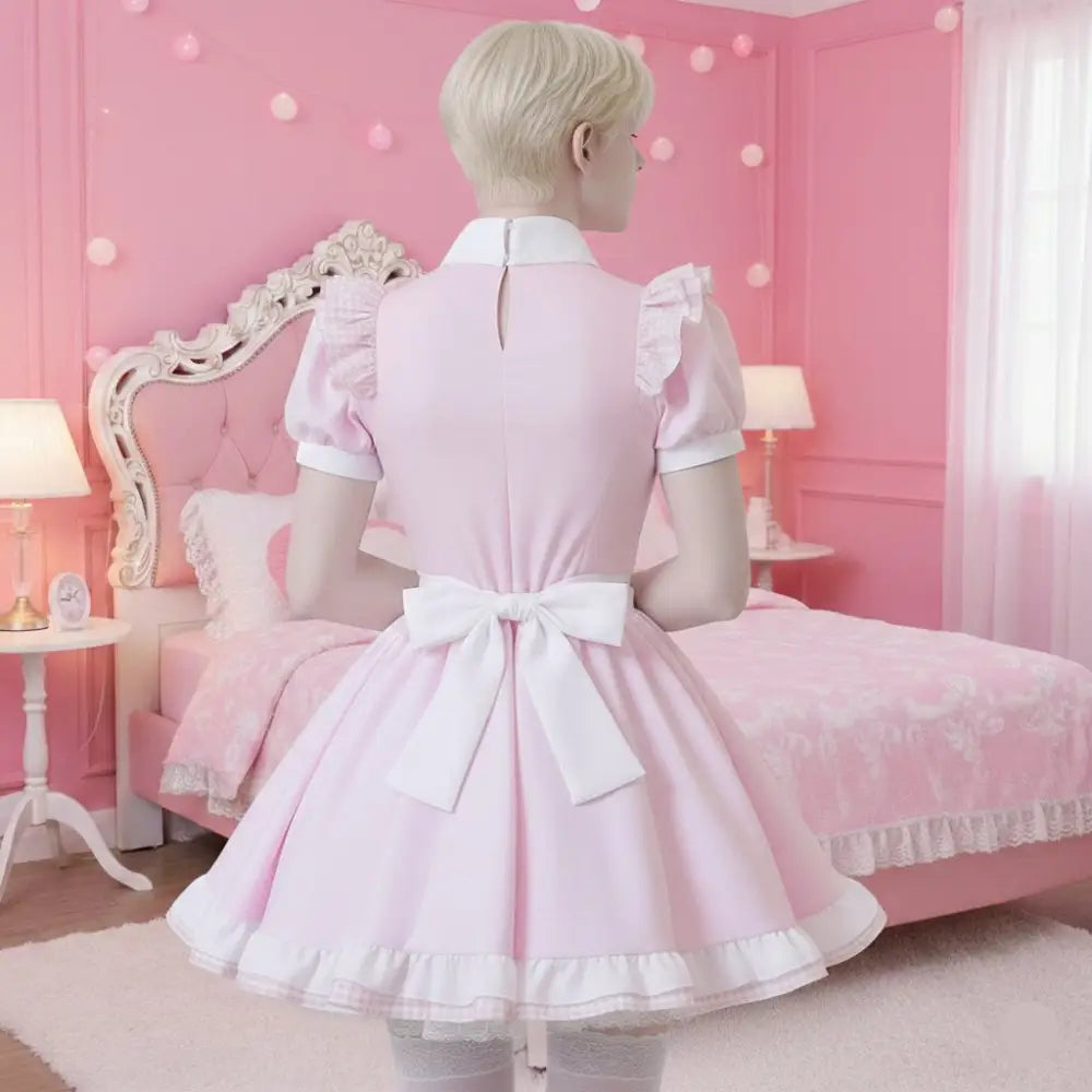 Man wearing a pink dress with white trim in a room with pink walls and furniture.