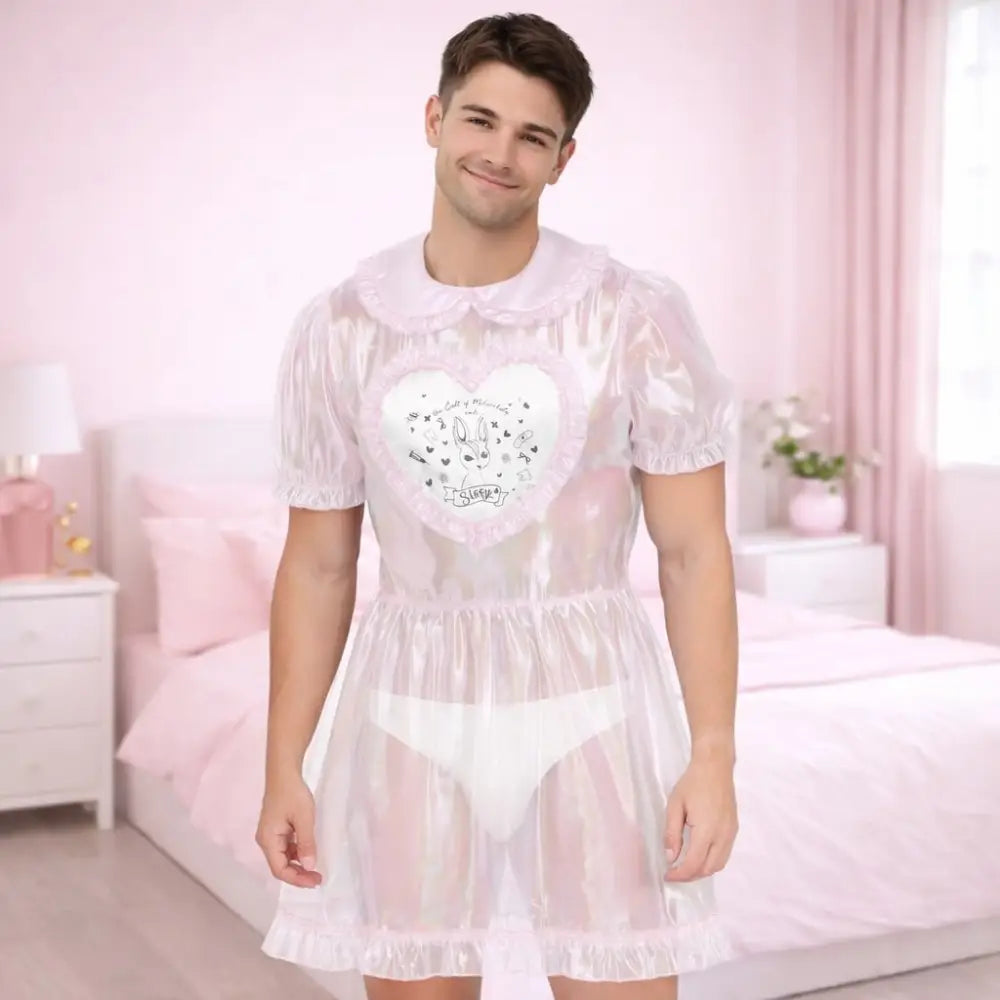 Man wearing a sheer white dress with a heart design in a pink bedroom.