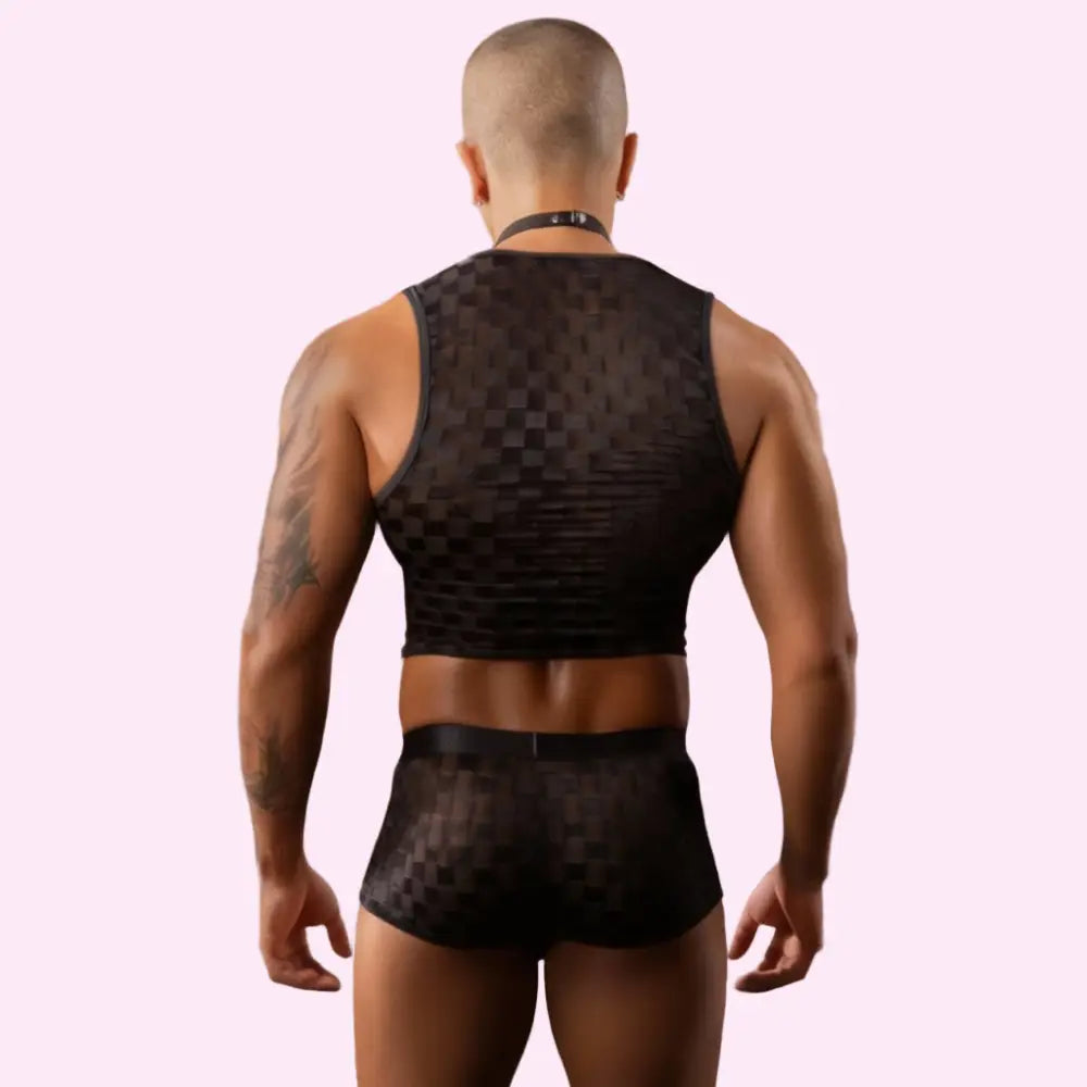 Person wearing black mesh lingerie in a pink bedroom