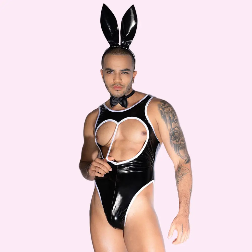 Person wearing a black latex outfit with cut-out design and rabbit ears on a white background