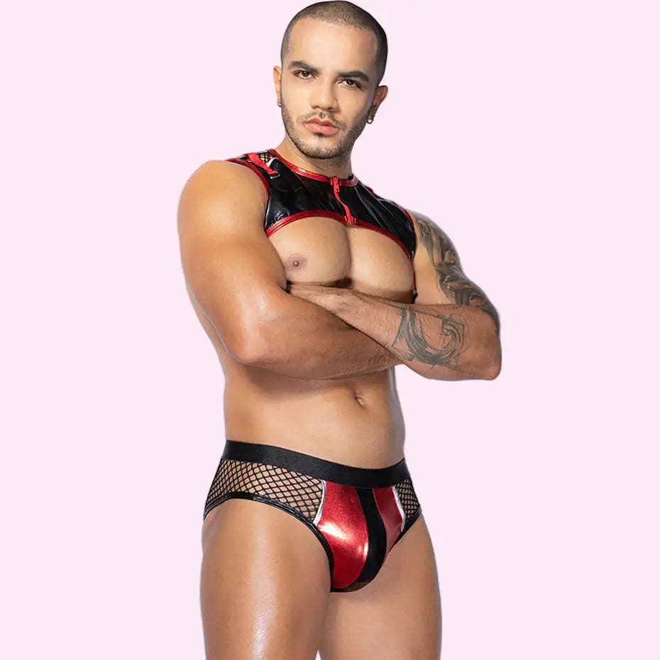 Man wearing a black and red swimsuit with fishnet details on a white background
