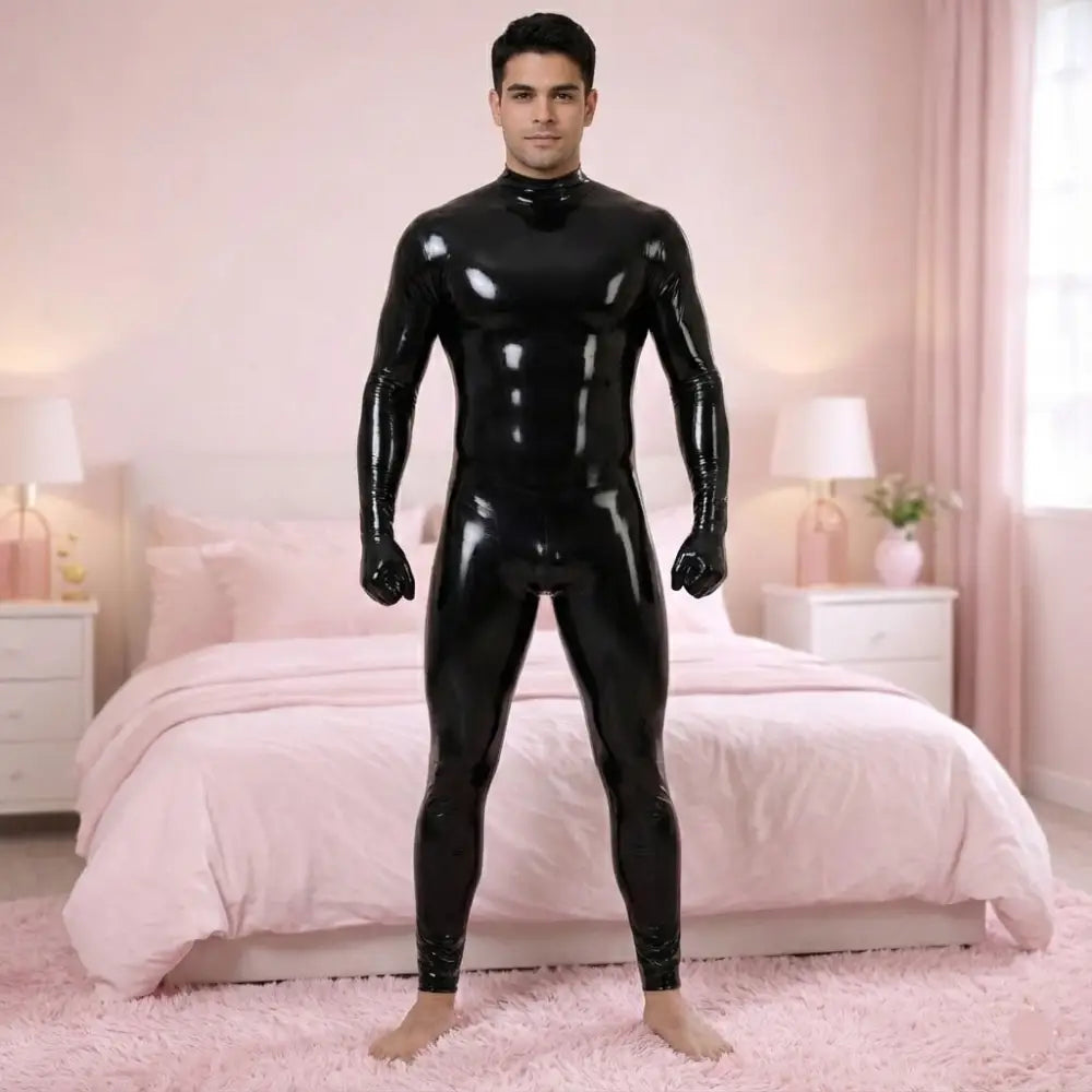 Man wearing a black latex suit in a bedroom with pink bedding and decor.